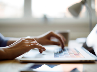 Woman using her laptop to take online Animal Assisted Intervention Courses.
