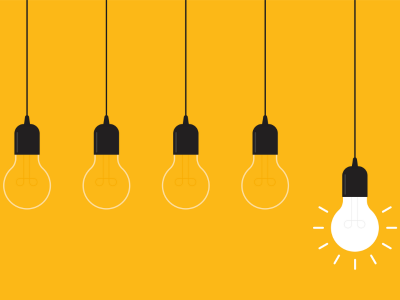 Concept of an idea depicted by hanging light bulbs with one glowing on a yellow background. 