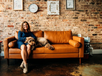Female therapist sits on couch with therapy dog