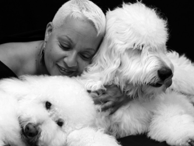 Woman hugs two large and fluffy therapy dogs