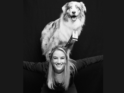 Black and white image of woman with therapy dog on her back