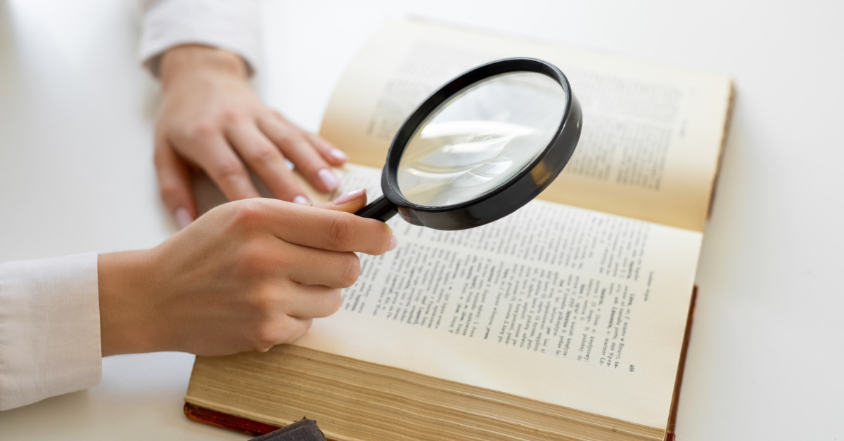 Person holding a magnifying glass over a dictionary defining animal-assisted intervention terminology